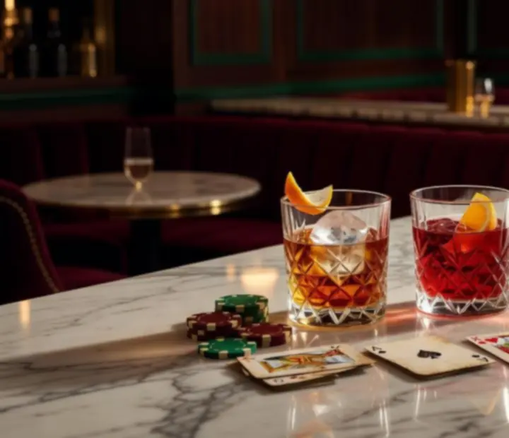Classic cocktails including an Old Fashioned and Negroni arranged beside subtle casino chips.