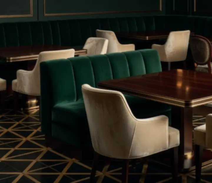 Dining room interior with ivory walls, emerald seating and bronze trim